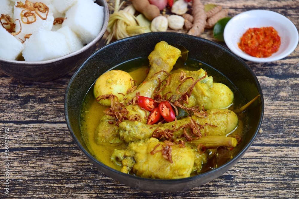 Opor ayam, chicken cooked in coconut milk from Indonesia, from Central Java, added with boiled eggs, served with lontong and sambal. Popular dish for lebaran or Eid al-Fitr Opor ayam, chicken cooked in coconut milk from Indonesia, from Central Java, added with boiled eggs, served with lontong and sambal. Popular dish for lebaran or Eid al-Fitr