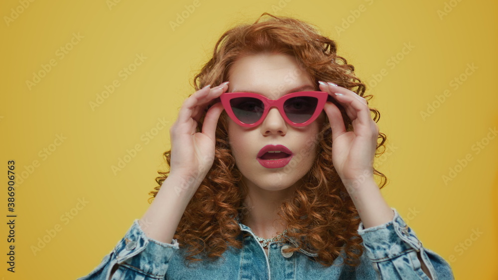 Woman wearing stylish sunglasses. Sexy lady pouting lips on yellow background Woman wearing stylish sunglasses. Sexy lady pouting lips on yellow background