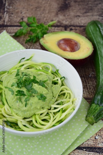Zucchini noodle or zoodles with avocado sauce garnish with parsley