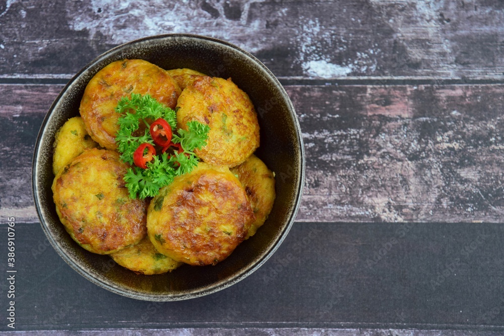 Perkedel, Indonesian fried potato minced beef patties garnish with parsley and chili in a bowl Perkedel, Indonesian fried potato minced beef patties garnish with parsley and chili in a bowl