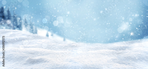 Christmas snow background with snow drifts and snow-covered blur forest