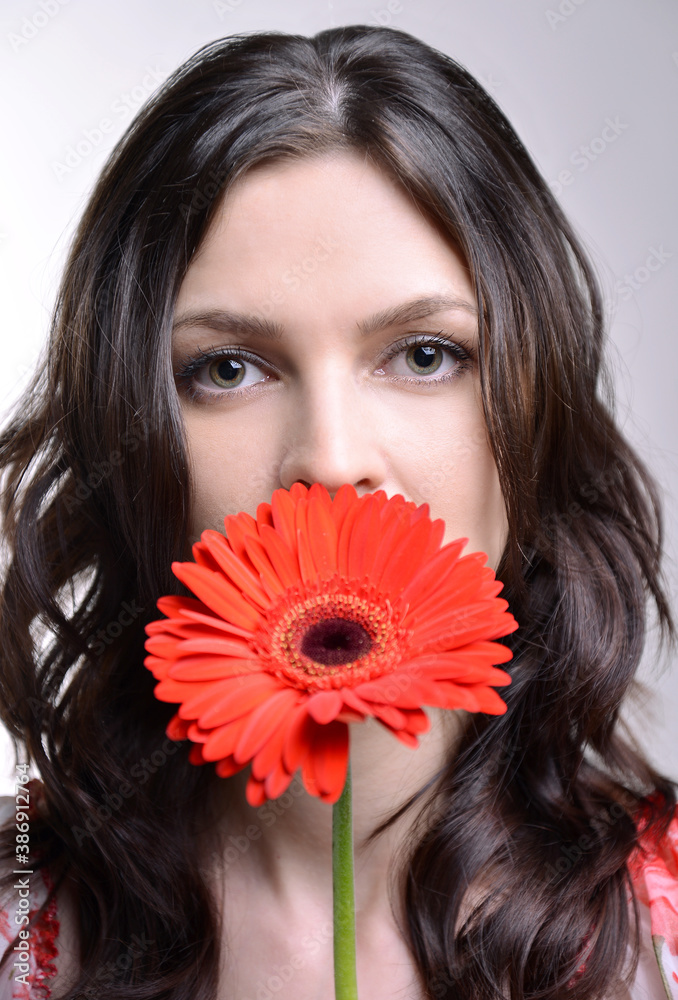 Very beautiful girl with a red flower. Brunette with a gerbera. Portrait. Plant Very beautiful girl with a red flower. Brunette with a gerbera. Portrait. Plant