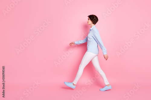 Full length body size profile side view of her she nice attractive serious content brown-haired girl walking copy space motion isolated over pink pastel color background