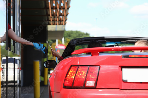 Φωτογραφία Woman in car pays with a bank card in fast food cafe
