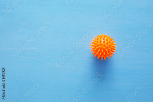 Abstract virus strain orange model of Coronavirus disease COVID-19 on blue wooden background with copy space.