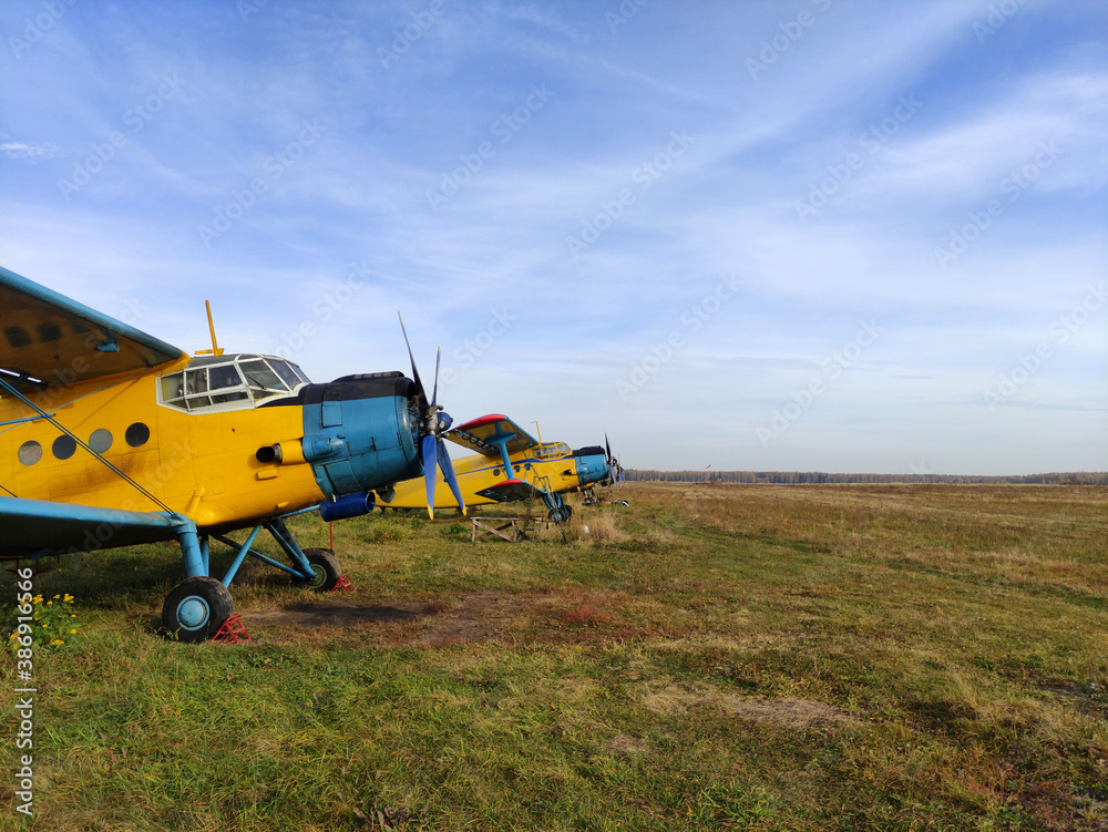 Parking yellow old piston aircraft biplanes with a propeller in the summer on the tarmac in Sunny weather Parking yellow old piston aircraft biplanes with a propeller in the summer on the tarmac in Sunny weather