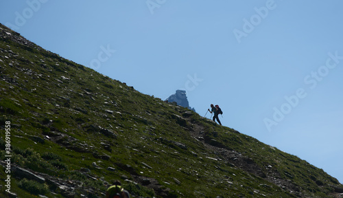 Photo Silhouette of mountaineer with trekking sticks ascending rocky mountain