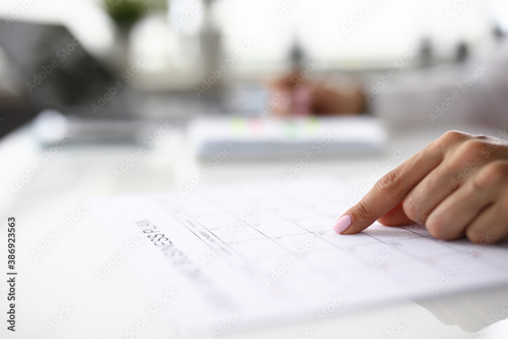 Woman's finger indicates date in business plan. Strategic planning of business tasks concept Woman's finger indicates date in business plan. Strategic planning of business tasks concept