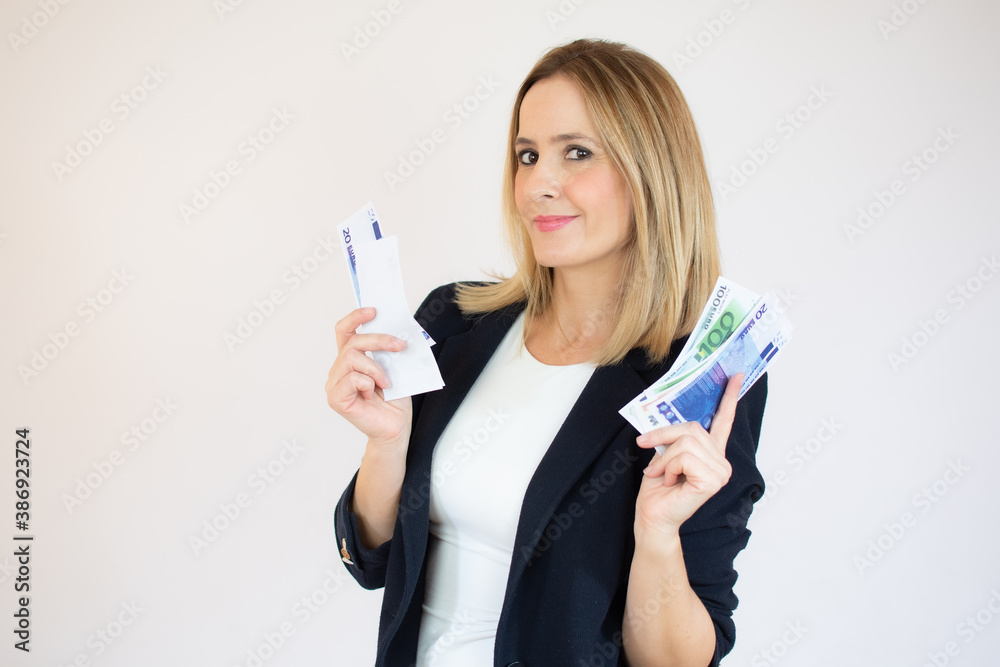 Young friendly businesswoman holding money in her hands and looking to the camera with a smile on her face on isolated white background. Concept of wealth, win, credit. Copy space Young friendly businesswoman holding money in her hands and looking to the camera with a smile on her face on isolated white background. Concept of wealth, win, credit. Copy space