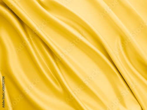 Beautiful smooth elegant wavy light yellow satin silk luxury cloth fabric texture, abstract background design. Copy space. 