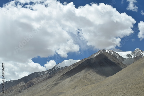 clouds over the mountains landscape with snow and mountains in the way of pangong lake