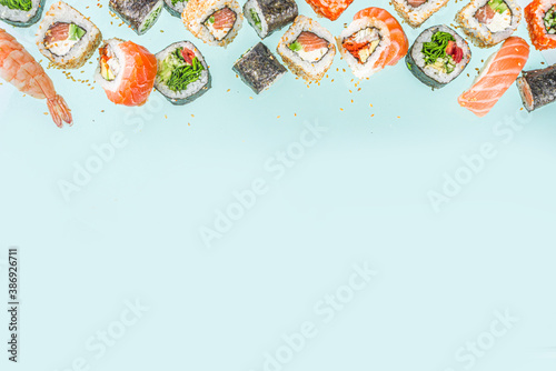 Flying sushi set with chopsticks. Various delicious japanese sushi, roll pieces and nigiri on light blue background