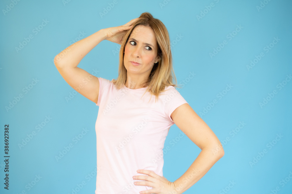 Portrait of a pensive casual woman looking away at copy space isolated over blue background Portrait of a pensive casual woman looking away at copy space isolated over blue background