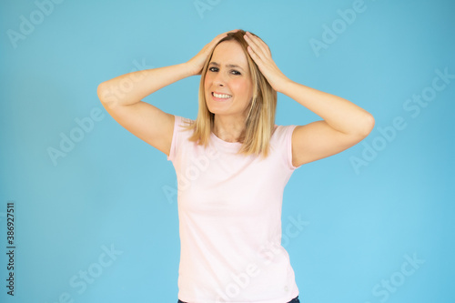 Image of shocked excited young lady standing isolated over blue background. Looking camera.