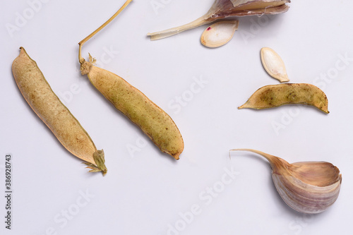 Garlic, pumpkin seeds, dried pea pods on a white background close-up
