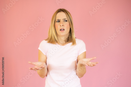 on a pink background young woman throw up his hand