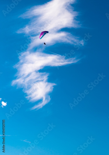 flying high in the sky, paraglider up in the air with a blue sky some clouds and copy space 