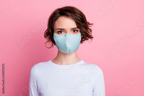 Portrait of attractive pretty girl look in camera wear blue fabric face mask isolated over pastel pink color background © deagreez