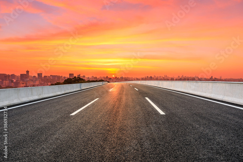 Empty asphalt road and city skyline with buildings in Hangzhou at sunrise.