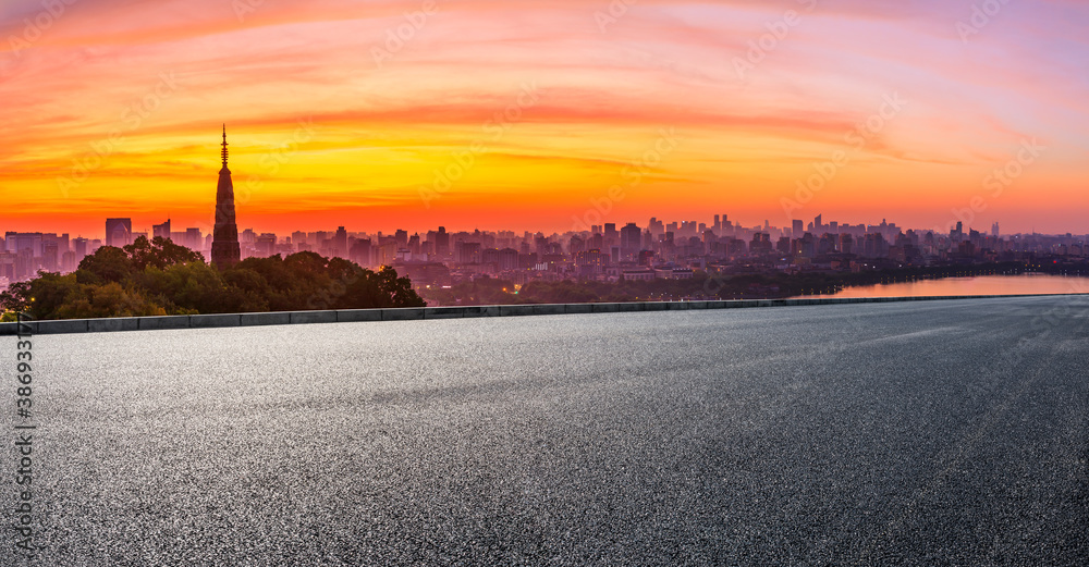 Asphalt road and city skyline with buildings in Hangzhou at sunrise.