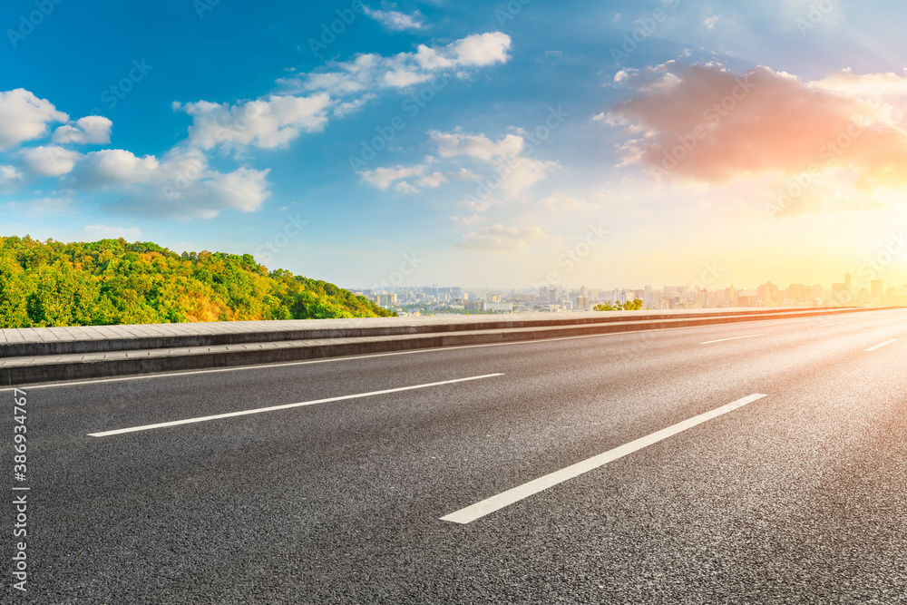 Naklejka premium Asphalt road and city skyline with buildings in Hangzhou at sunrise.