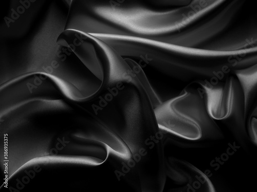 Beautiful elegant dark silver grey or black satin silk luxury cloth fabric texture, abstract background design.