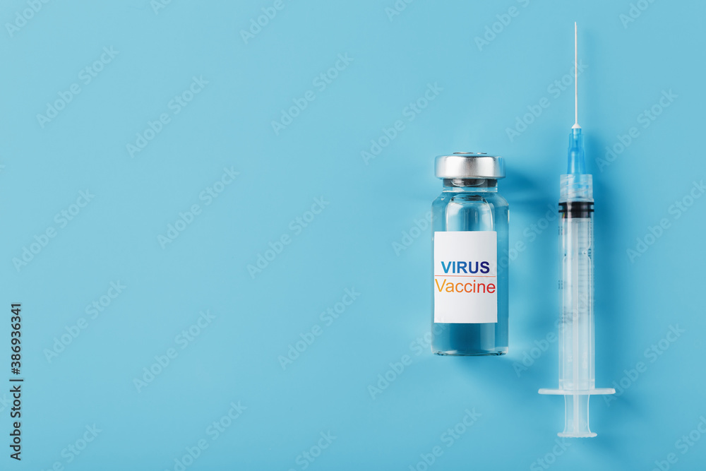 Syringes and ampoule with the vaccine against the Virus from diseases on a blue background.