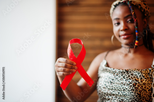 Картината върху платно AIDS awareness. Stylish african american woman hold red ribbon.