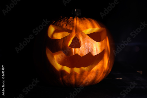 Carved Halloween pumpkin, jack lantern (Jack-o'-lantern). Spooky laughing, scary head in the darkness. © Longfin Media