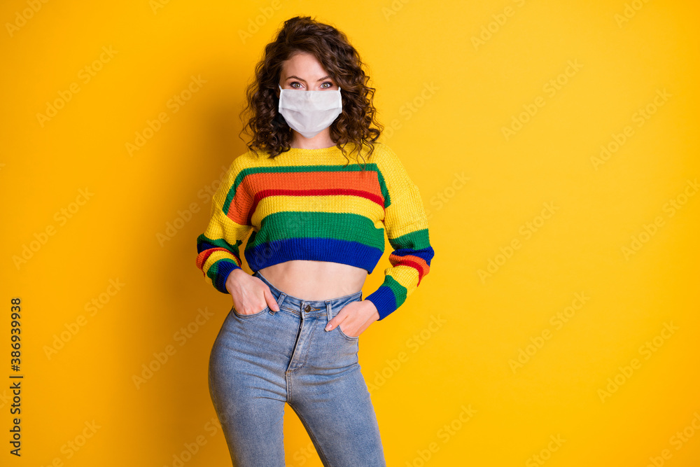 Photo portrait of confident girl with two hands in pockets wear medical mask isolated on bright yellow colored background - obrazy, fototapety, plakaty 