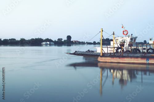 Barcaza de transporte fluvial a orillas del río Danubio. Barcaza de transporte de carga en la orilla del río al atardecer en el pueblo de Nufaru, Rumanía. photo