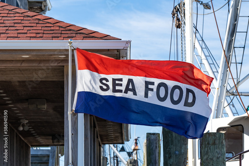 red white and blue striped sea food flag outside a fish market at the waterfront