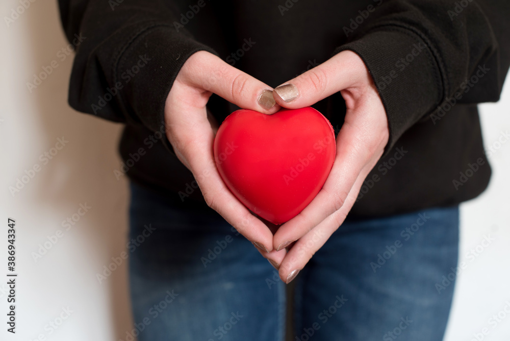 Dos manos blancas sujetando un corazón rojo Dos manos blancas sujetando un corazón rojo