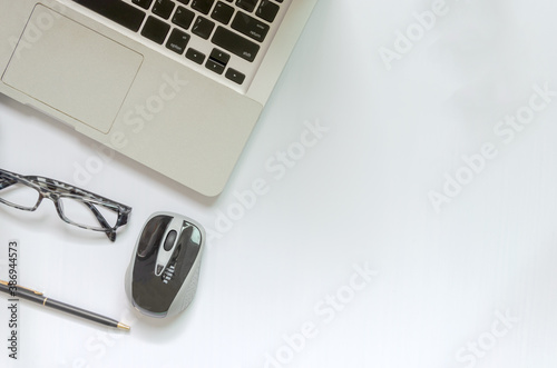 Computer laptop and glasses on white background