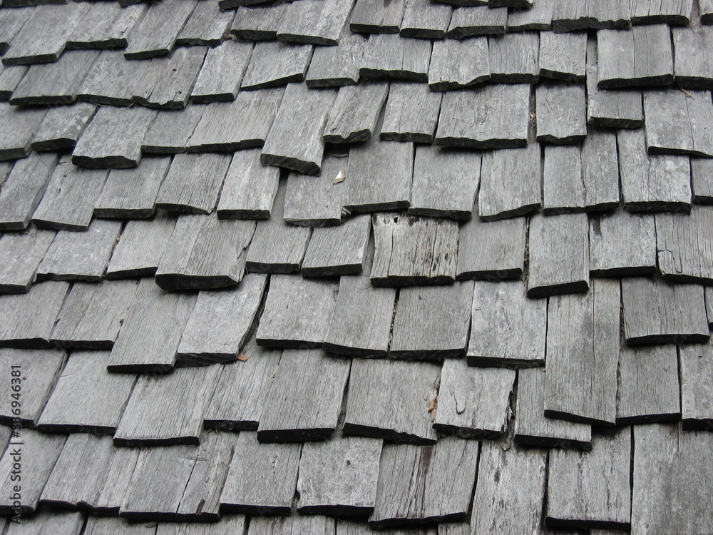 Weathered wooden roof composed of overlapping wooden boards. Rough and uniform texture. Weathered wooden roof composed of overlapping wooden boards. Rough and uniform texture.