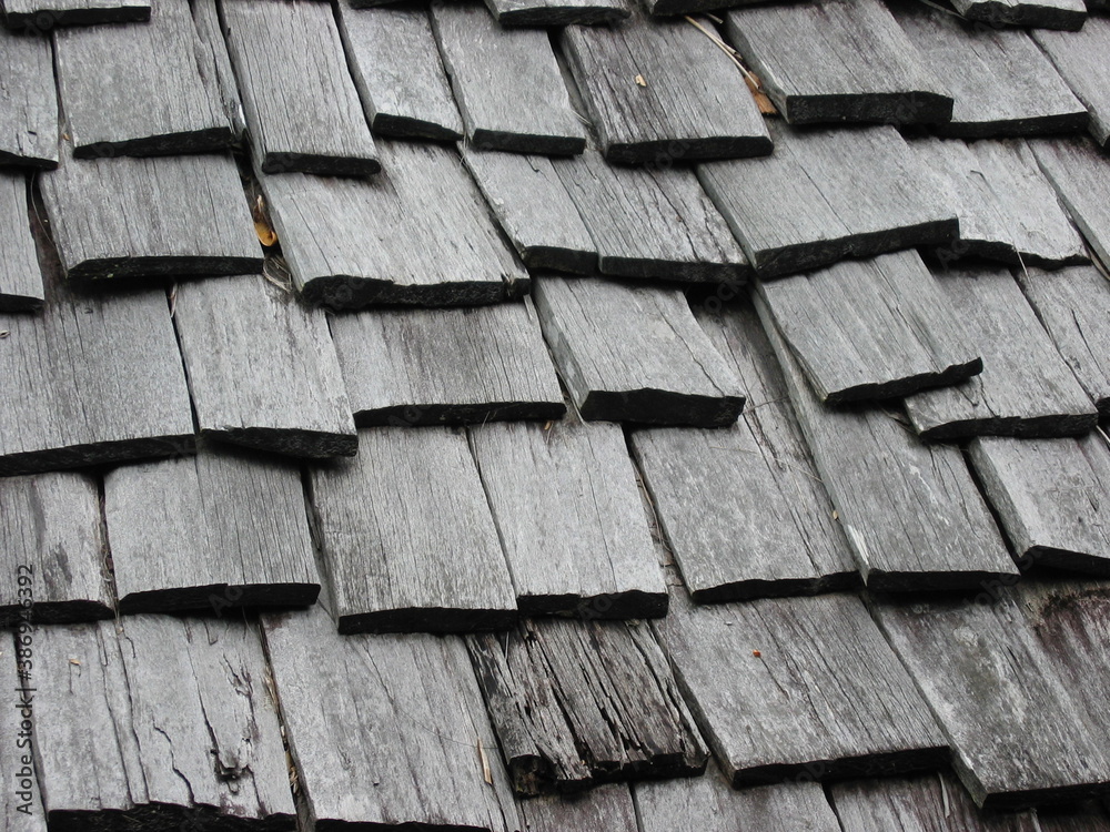 Weathered wooden roof composed of overlapping wooden boards. Rough and uniform texture. Weathered wooden roof composed of overlapping wooden boards. Rough and uniform texture.