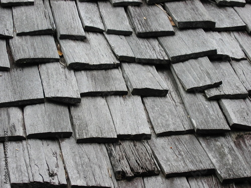 Weathered wooden roof composed of overlapping wooden boards. Rough and uniform texture.