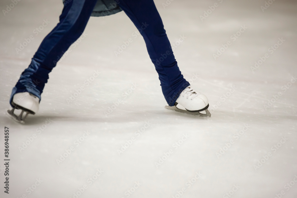 Figure skates legs on ice. Figure skating school. Young figure skaters practicing at indoor skating rink. Kid learning to ice skate. Figure skates legs on ice. Figure skating school. Young figure skaters practicing at indoor skating rink. Kid learning to ice skate.