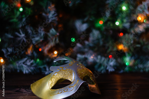 Christmas carnival mask on background of twinkling garland of lights.