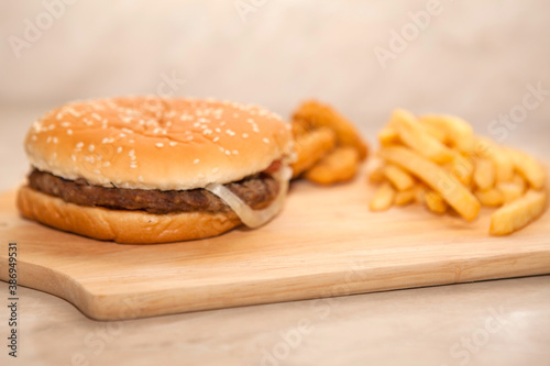 Close up of tasty burger with french fries on cutting board