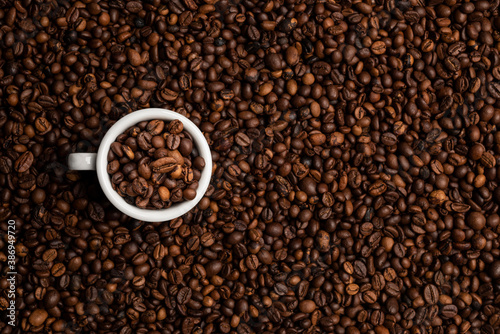 cup full of coffee beans over a background of coffee beans