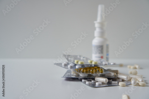 Assorted pharmaceutical medicine pills, tablets and capsules, nasal spray