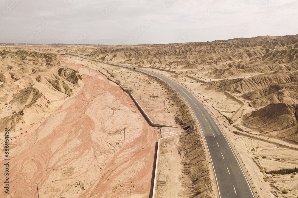 Dryness land with erosion terrain with highway crossing.