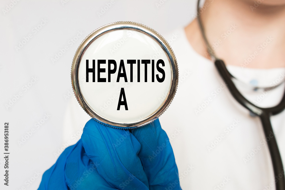 The doctor's blue - gloved hands show the word HEPATITIS A - . a gloved hand on a white background. Medical concept. the medicine The doctor's blue - gloved hands show the word HEPATITIS A - . a gloved hand on a white background. Medical concept. the medicine