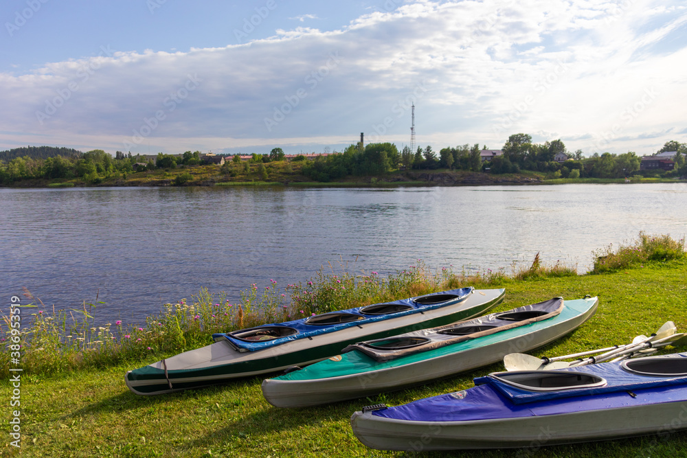 Obraz premium colorful boats for sports and canoe trips on the ground near a natural reservoir,river,lake