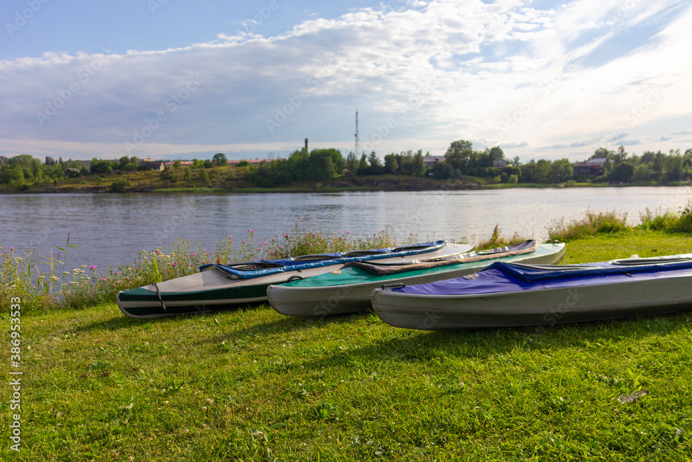 colorful boats for sports and canoe trips on the ground near a natural reservoir,river,lake