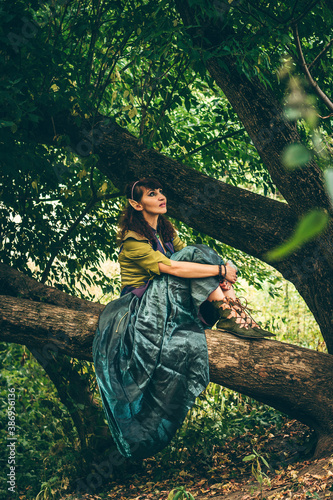 Slika na platnu Elf girl sits on a branch in a magic forest and dreams