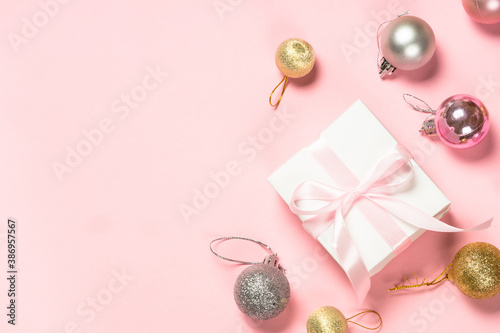 Christmas pink flat lay background with present box and decorations.