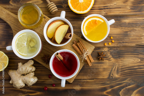 Top view of different teas in the white cups on the wooden background