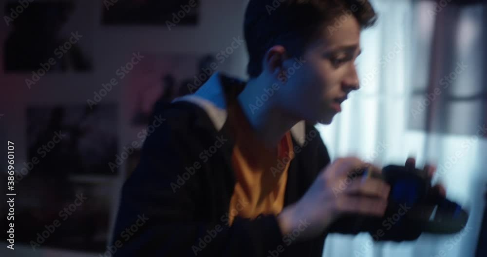 A gamer boy gets upset due to a game and throws the headphones on the door. Medium shot. Slow-motion. A gamer boy gets upset due to a game and throws the headphones on the door. Medium shot. Slow-motion.